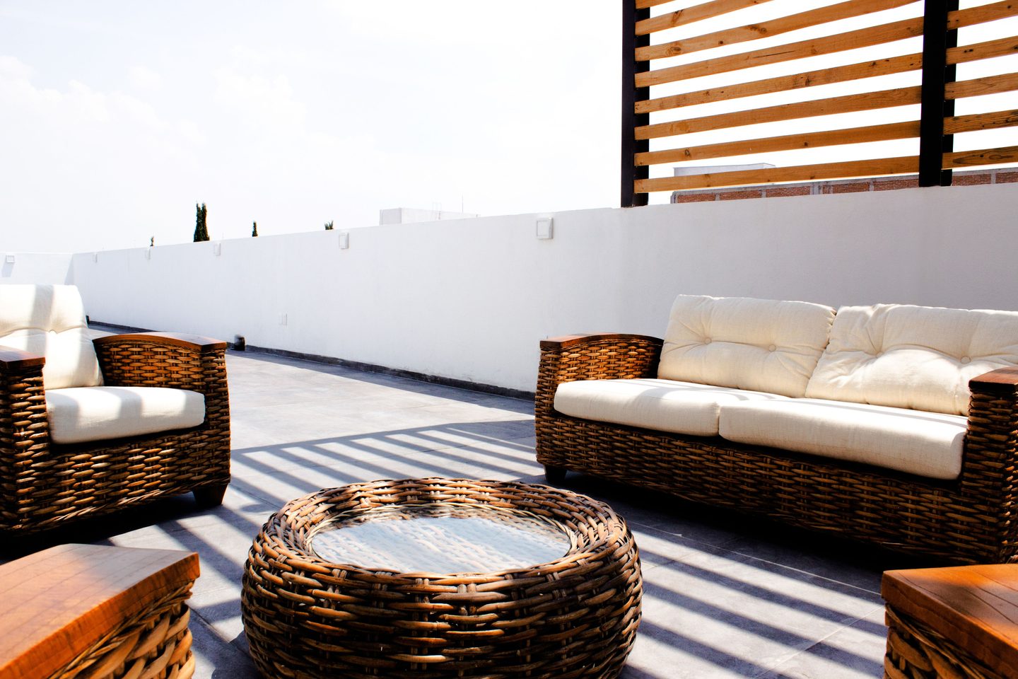 Terraza al aire libre con sofás de ratán y mesa redonda
