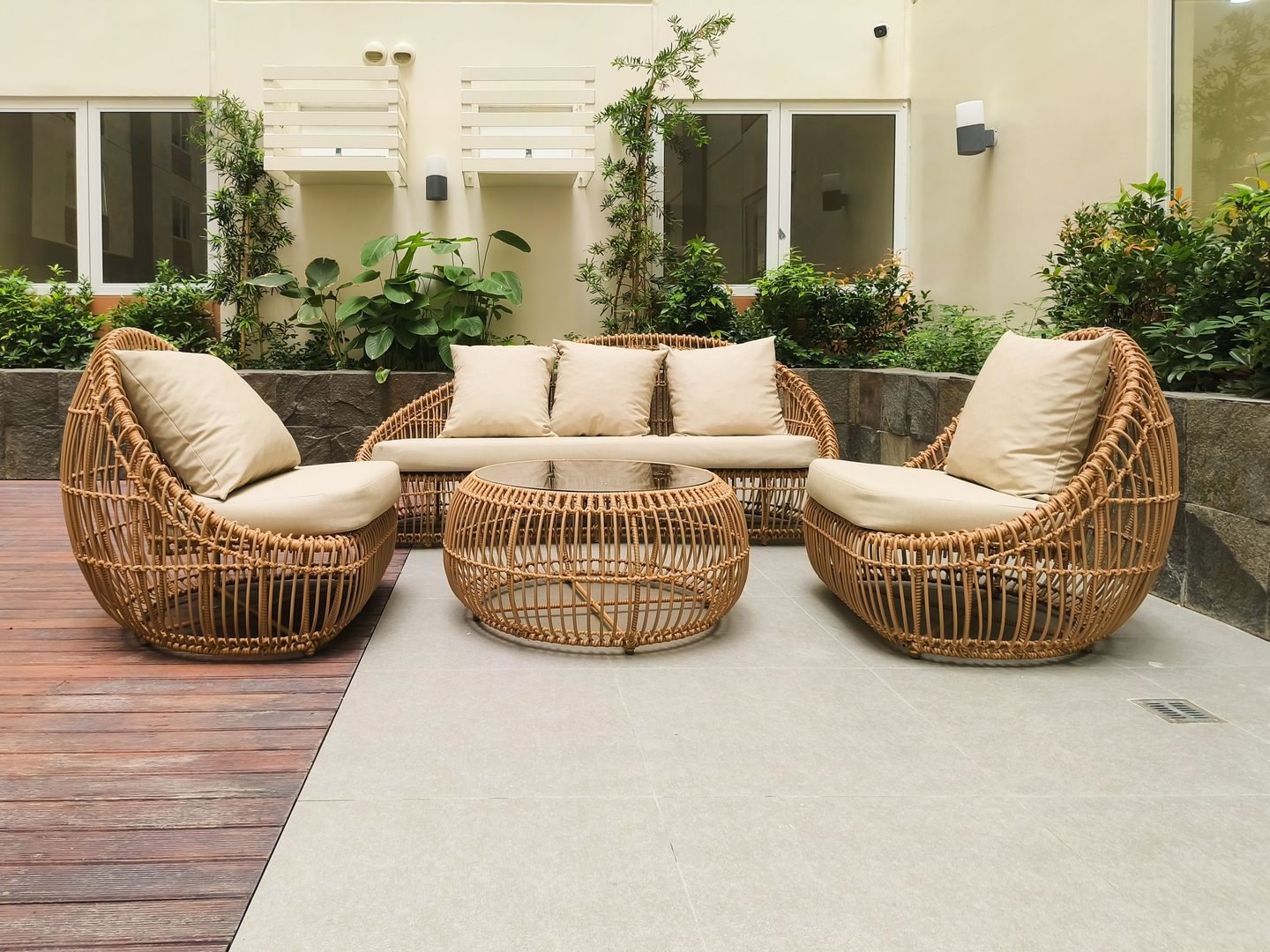 Patio exterior con sillones de ratán y plantas